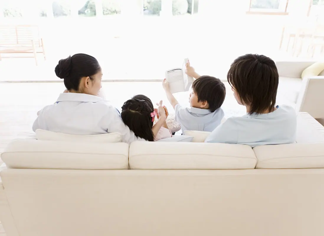 ソファで会話する4人家族の後ろ姿の写真