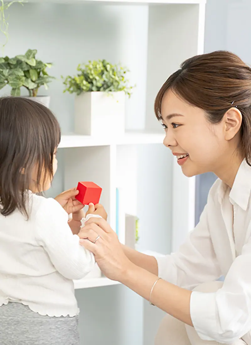 積み木を持つ女の子とお母さんの写真