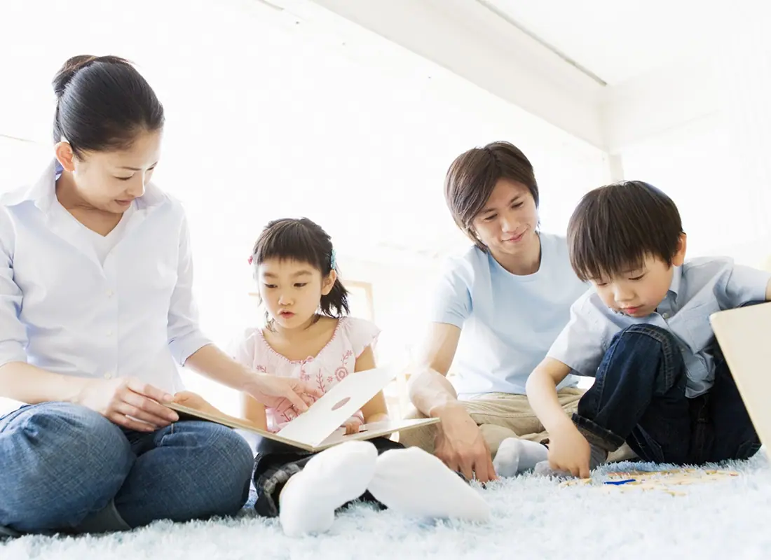 4人の親子がリビングでくつろいでいる写真