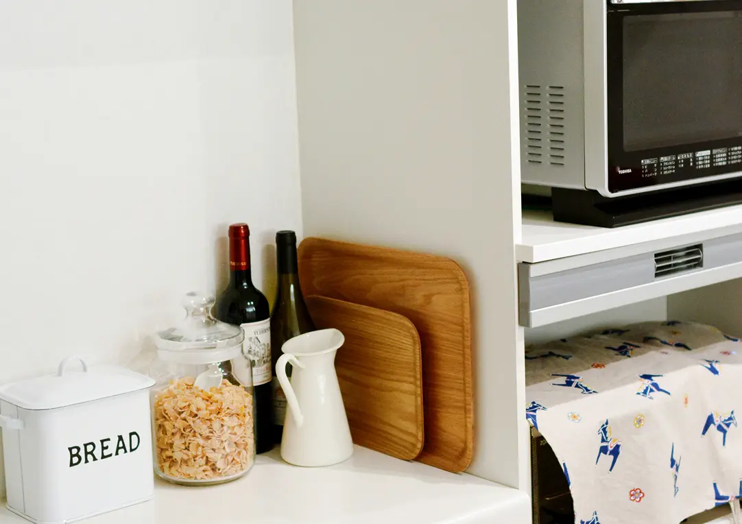 川村家のキッチンの様子、電子レンジ、トレー、調味料などが並ぶ